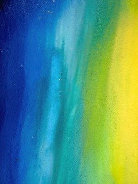 Arka plan olarak maviden sarıya doğru renk eğimine sahip boyalı bir duvar.