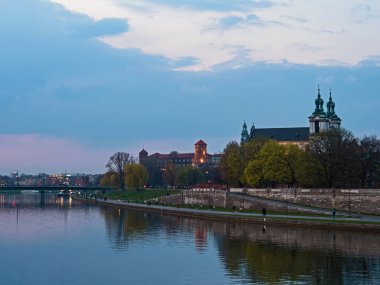 Krakow, Küçük Polonya, Polonya - 05 Nisan 2019: Vistula Nehri 'nin kıyısındaki Aziz Paul Bazilikası' nın mavi saatte görüntüsü