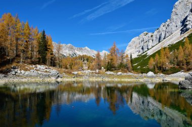 Triglav Gölleri Vadisi 'ndeki Çifte Göl manzarası ve Julian Alpleri, Gorenjska, Slovenya' daki göldeki ahşap dağ kulübesi