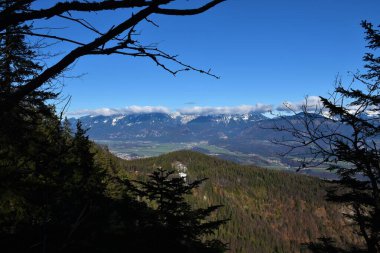 Slovenya 'nın Gorenjska kentinde kışın doruklarında bulutların olduğu Karavanke sıradağlarının manzarası
