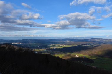 Slovenya 'nın Dolenjska kentindeki Grosuplje kasabasının çevresindeki kırsal manzarada tarlalar, köyler ve orman kaplı tepeler görülüyor