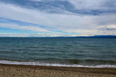 Adriyatik Denizi kıyıları, uzak mesafelerde Alplerde karla kaplı zirveler.
