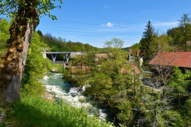 Hırvatistan 'ın Karlovac ilçesindeki Slunj kasabasının yanında akan Korana Nehri manzarası ve arkasında bir köprü