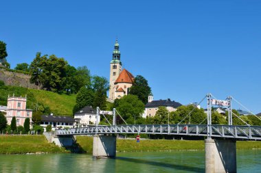 Salzburg, Avusturya 'daki Salzach Nehri üzerindeki Millnersteg Köprüsü ve Meryem Ana Kilisesi Kilisesi Kilisesi Kilisesi.