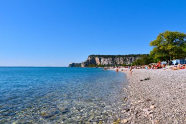 Falesie di Duino, İtalya - 29 Eylül 2023: İtalya 'nın Duino-Aurisina kentindeki Portopiccolo Sistiana adacik denizinin kıyısında