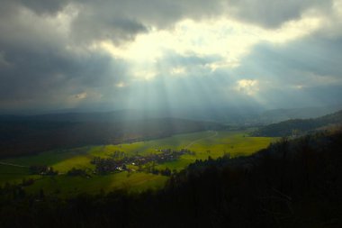 Slovenya 'nın Notranjska kentinde bulutlu bir günde ormanla çevrili Strmca köyünün manzarası
