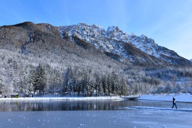 Slovenya 'nın Kranjska Gora kenti yakınlarındaki Jasna Gölü üzerindeki Rusica Dağı' nın iskelesinde yürüyen bir kişi görülüyor.