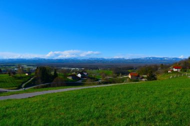 Village Ostrc bellow Gorjanci and hills in Dolenjska, Slovenia clipart