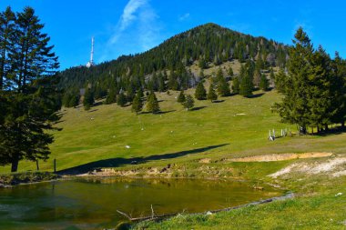 Slopes of Veliki Zvoh hill and antenna at Krvavec with a lake bellow in Gorenjska, Slovenia clipart