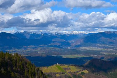 Slovenya 'nın Gorenjska kentindeki Karavanke dağlarındaki dağ sıralarının manzarası ve ovaların böğürmesi