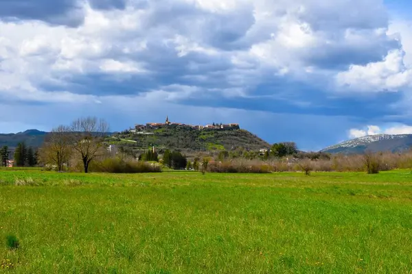 Hırvatistan 'ın Istria kentinde eski Buzet kentinde yeşil tarlalar ve gökyüzünde kara bulutlar haykırıyor