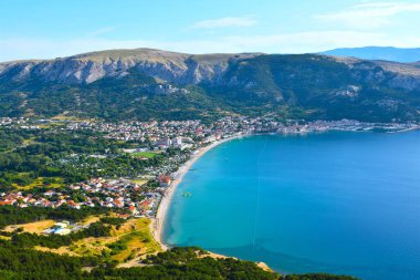 Hırvatistan 'ın Kvarner kentindeki Adriyatik Denizi' nin bir körfezinde dağları haykıran Baska kasabasının manzarası
