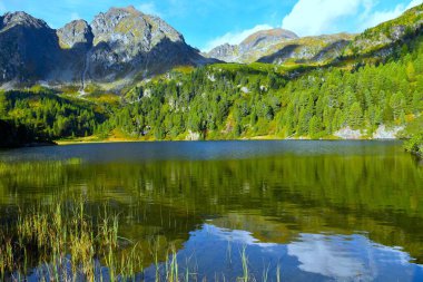 Unterere Zwiefler Gölü manzarası. Suda yansıması var. Solktler doğa parkındaki dağ tepeleri Niedere Tauern, Styria, Avusturya 'da.