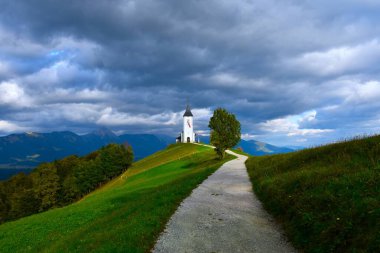 Slovenya 'nın Gorenjska kentindeki Aziz Primoz ve Felician Kilisesi' ne giden patika ve yeşil çayırlar çınlıyor.