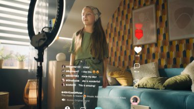 Kız dans ediyor ve şarkı söylüyor, video seyrediyor, filtreleri değiştiriyor, mobil uygulamalarda içerik yaratıyor, trend videoları çekiyor. Yorumlar ve beğeni ile 3B projeksiyon hologramı sosyal ağ arayüzü