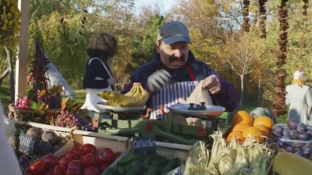 Vendeur Agriculteur Senior Pèse Les Bananes Sur Balance Les Met — Video
