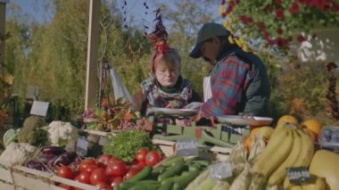 Birkaç yaşlı çiftçi öğle yemeği molası veriyor, komşunun pişirdiği etin tadına bakıyor ve favori işi yaparak mutluluğu hissediyorlar. Yerel çiftçi pazarında hafta sonu. Vejetaryen ve organik yiyecekler. Tarım.