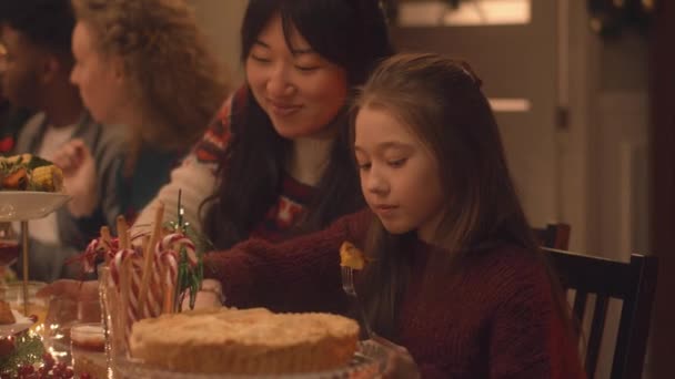快乐的多元文化家庭庆祝圣诞节或2023年新年 亚洲女孩吃喝玩乐 有盘子和蜡烛的节日餐桌 家中温馨的圣诞大餐气氛 — 图库视频影像