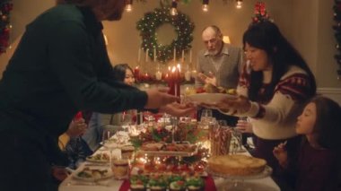Mutlu büyük aile masada oturup Noel 'i ya da evde yeni yılı kutluyor. Büyükannem sofrayı geleneksel hindiyle hazırladı. Aile Noel yemeğinin sıcak atmosferi. Noel Arifesi.