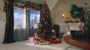 Taşaklı ağaç, oyuncaklar, yanıp sönen ışıklar, paketlenmiş hediyeler ve hediye kutuları oturma odasında duruyor. Noel ve Yeni Yıl Festivali iç dekorasyonu. Kış tatillerinde rahat bir dairede atmosfer..