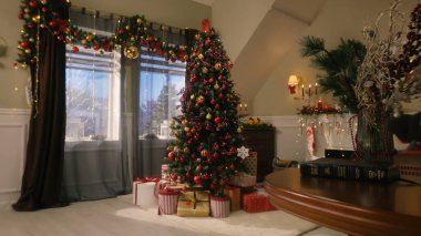 Taşaklı ağaç, oyuncaklar, yanıp sönen ışıklar, paketlenmiş hediyeler ve hediye kutuları oturma odasında duruyor. Noel ve Yeni Yıl Festivali iç dekorasyonu. Kış tatillerinde rahat bir dairede atmosfer..