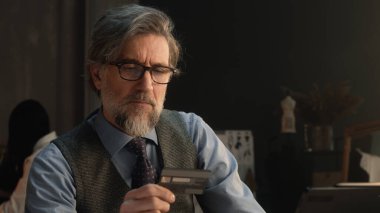 Tailor using tablet, transferring money on bank card, paying for service online during work in luxury atelier. Female tailor works on elegant suit on background. Fashion and entrepreneurship concept.