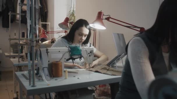 女装设计师坐在缝纫机前 用笔记本电脑用桌子裁剪现代婚纱 做背景定制服装的女裁缝 大堂或缝纫车间 时尚概念 — 图库视频影像