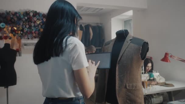 Female Tailor Keeps Hand Tablet Zoomes Sketch Touches Elegant Suit — Stockvideo