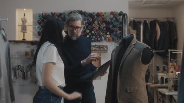 Male Mature Fashion Designer Shows Sketch Future Jacket Seamstress Laptop — Stock video
