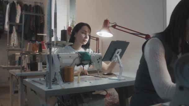 女性时装设计师或服装制造商触摸平板电脑 坐在缝纫机和裁缝机前 做背景定制服装的女裁缝 大堂或缝纫车间 时尚概念 — 图库视频影像