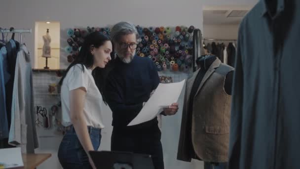 Male Mature Fashion Designer Discusses Sketch Drawing Future Suit Jacket — Vídeo de stock