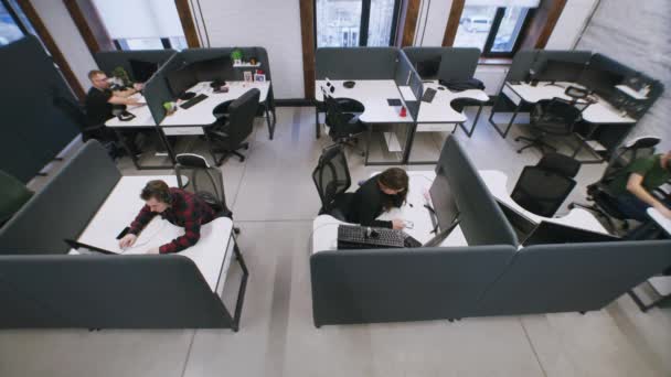 在同事办公室工作 与计算机一起坐在桌旁的人 女商人通过电话上网 成年男子来到同事身边 帮助完成项目任务 安全摄像头拍摄 — 图库视频影像