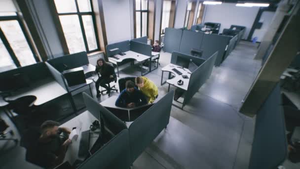 現代的なデザインのオフィスで働き コンピュータとテーブルに座っている人々 スタートアップやプロジェクト計画について話し合うカップル 男は廊下を歩く コワーキングコンセプト 防犯カメラの撮影 — ストック動画