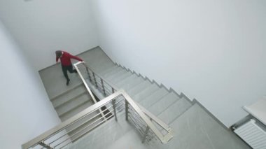 Modern iş merkezinin merdivenlerindeki CCTV kameralarından görüntüler. Meslektaşlar üst kattaki ofise gidip işi tartışırlar. İzleme sistemi, izleme ve güvenlik kavramı. Güvenlik kamerası kaydı..