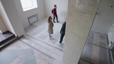 Oteldeki ya da iş merkezindeki güvenlik kameralarından görüntüler. Kadınlar ve erkekler lobi ve resepsiyon yenileme detaylarını tartışırlar. İzleme ve izleme sistemi kavramı. Güvenlik kamerası görüntüsü.