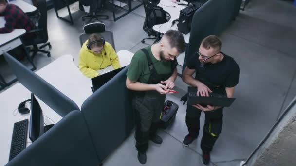 現代的なデザインのオフィスで働き コンピュータとテーブルに座っている人々 ラップトップ上のセキュリティカメラから画像を見て それを回し ビューを設定する力学 防犯カメラの撮影 — ストック動画