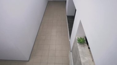 Bayan sekreter iş yerine gider. Gözlüklü adam resepsiyona gelir ve çalışma evraklarını alır. İş arkadaşlarıyla koridorda buluşup selamlaşıyorlar, iş tartışıyorlar. İş merkezi. Güvenlik kamerası kaydı..