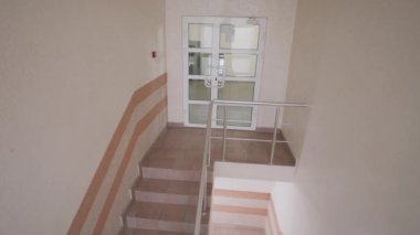 Yetişkin bir adam üst kattaki merdivenlerden çıkıp kapıyı açıyor. Meslektaşlar koridorda yürür. Modern iş merkezinin merdivenlerindeki iş adamları iş süreçleri arasında. Güvenlik kameraları ve CCTV.