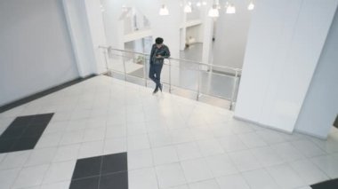 Afro-Amerikalı adam iş merkezinin lobisinde dikiliyor ve konuşuyor. İzleme ve izleme sistemi. Gözlem ve CCTV teknolojileri. Sosyal savunma kavramı. Güvenlik kamerası kaydı.
