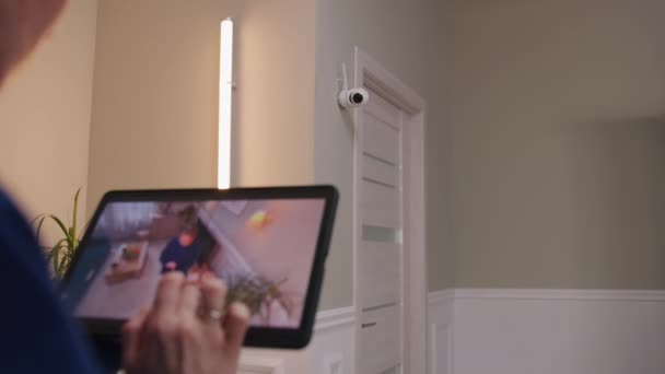 女人们在安装后检查摄像头 她在家里设置了闭路电视摄像头的角度 并使用数字平板和应用程序进行旋转 监测系统 安全和隐私概念 放大镜头 — 图库视频影像