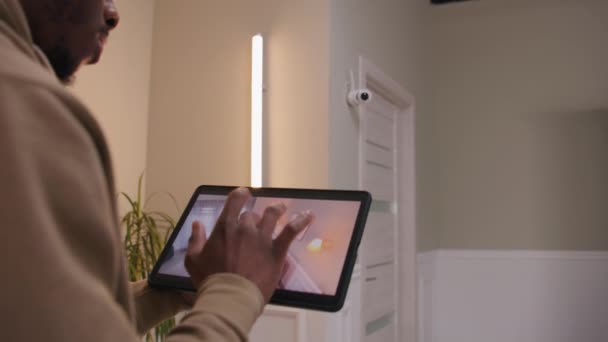 Afroamerikaner Überprüft Überwachungskamera Nach Installation Mit Digitalem Tablet Und App — Stockvideo