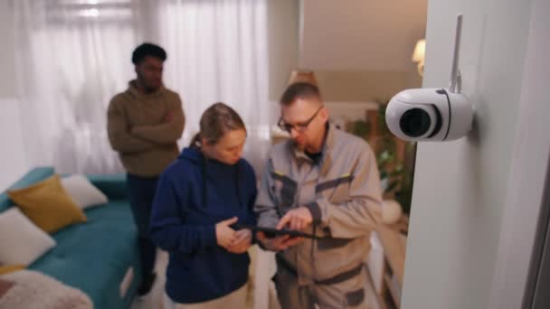 安装程序使用数码平板电脑在多民族家庭的家中安装了安全摄像头 在专业应用中 人们检查闭路电视摄像机的运动传感器 跟踪系统 安全和隐私的概念 — 图库视频影像