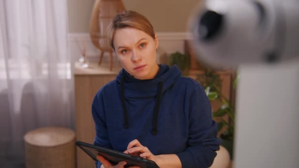 白人女性は防犯カメラを設置してる 女性は自宅でCctvカメラの角度を設定し デジタルタブレットコンピュータやアプリケーションでそれを回転させます 追跡システム 安全性とプライバシーの概念 ズームアウト — ストック動画