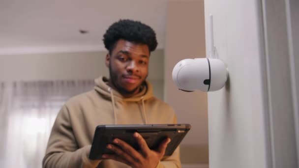 非裔美国人安装了摄像头 人们在家里设置闭路电视摄像头的角度 并用数字平板和应用程序旋转摄像机 监测系统 安全和隐私概念 放大镜头 — 图库视频影像