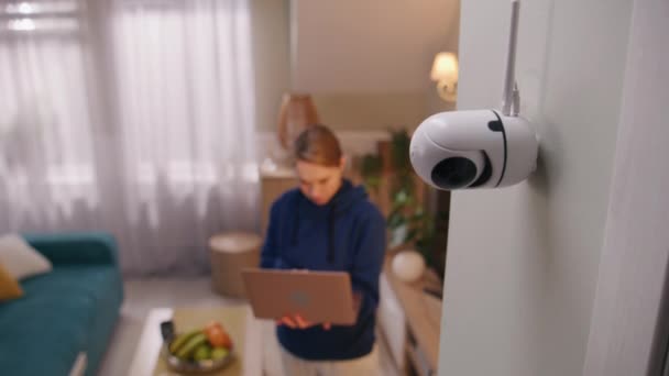 白人女人安装了监控摄像头妇女在家里设置闭路电视摄像头的角度 并使用笔记本电脑和专业软件轮流使用 监测系统的概念 安全和隐私 — 图库视频影像