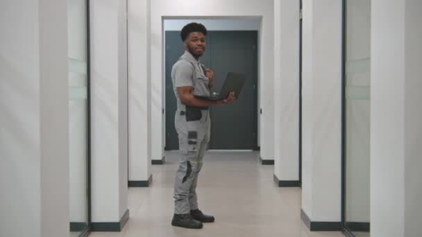 Afro American Security Cameras Installer Uniform Stands Corridor Laptop Looks — Vídeo de Stock