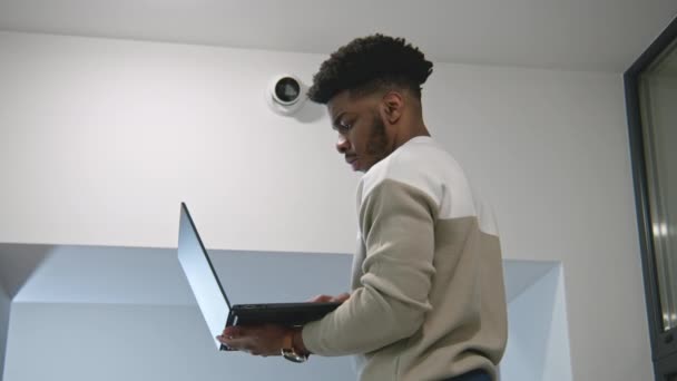 Африканский Американец Устанавливает Камеры Безопасности Офисном Коридоре Используя Ноутбук Установщик — стоковое видео