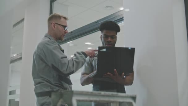 Двое Мужчин Униформе Устанавливают Камеры Видеонаблюдения Интернет Помощью Ноутбука Офисе — стоковое видео