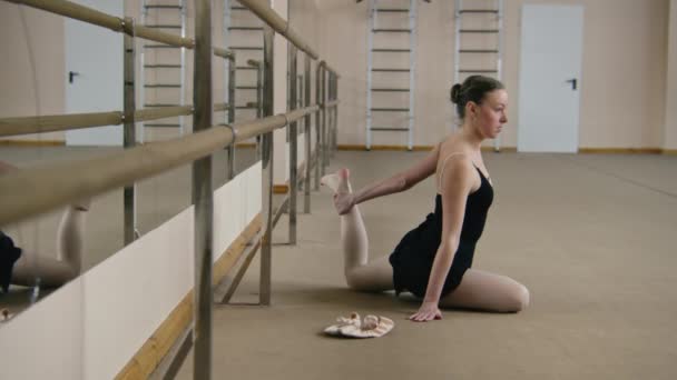 Танцовщица Балета Тренировочном Костюме Возле Балетной Стойки Растягивает Ноги Репетирует — стоковое видео