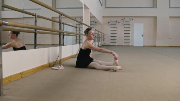 Танцівниця Балету Навчальному Костюмі Біля Балетного Барру Розтягує Ноги Перед — стокове відео